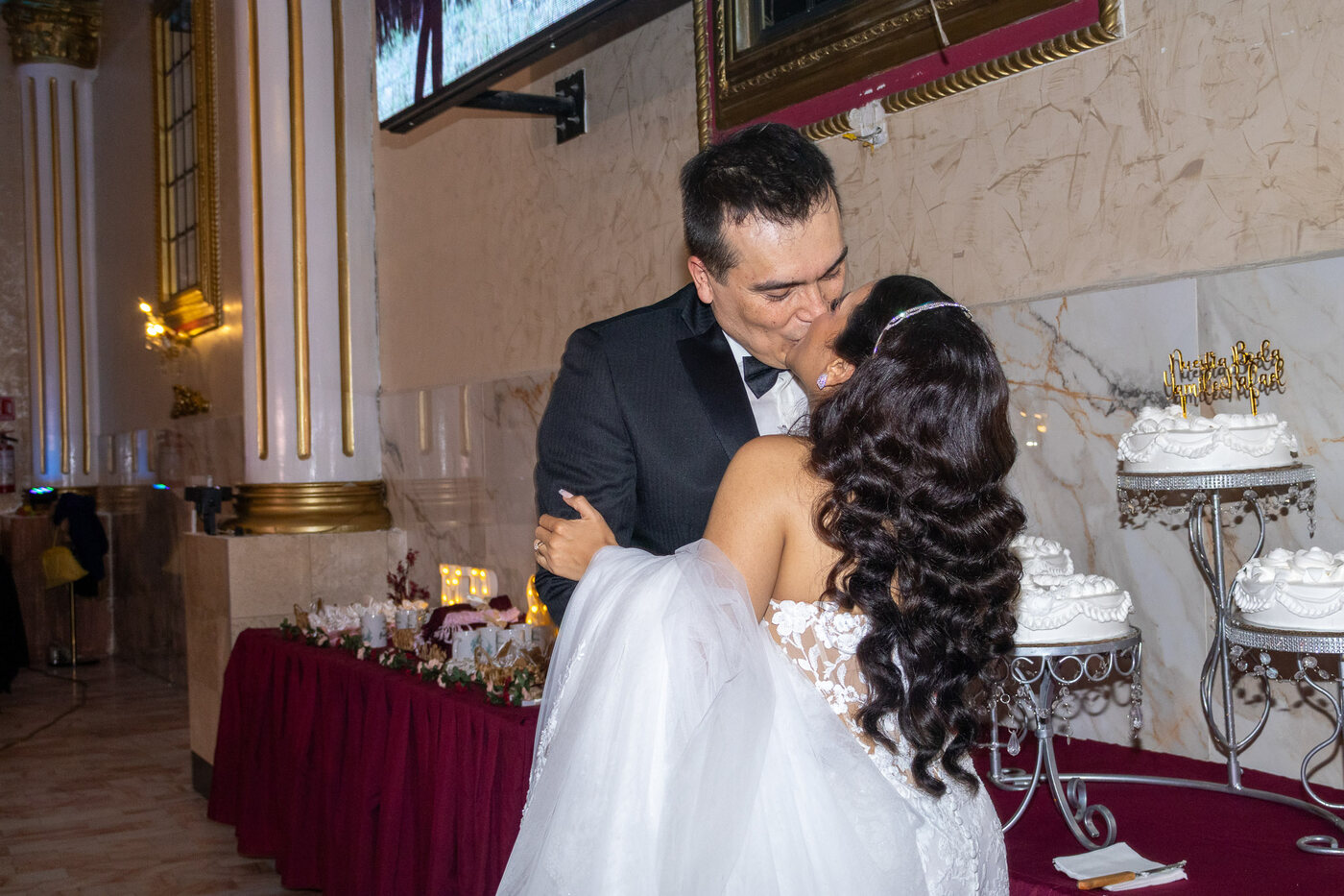 Novios abrazados junto al pastel de bodas