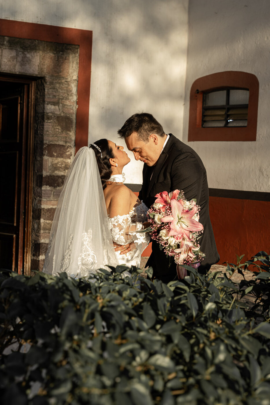Novios besándose en el jardín con el ramo