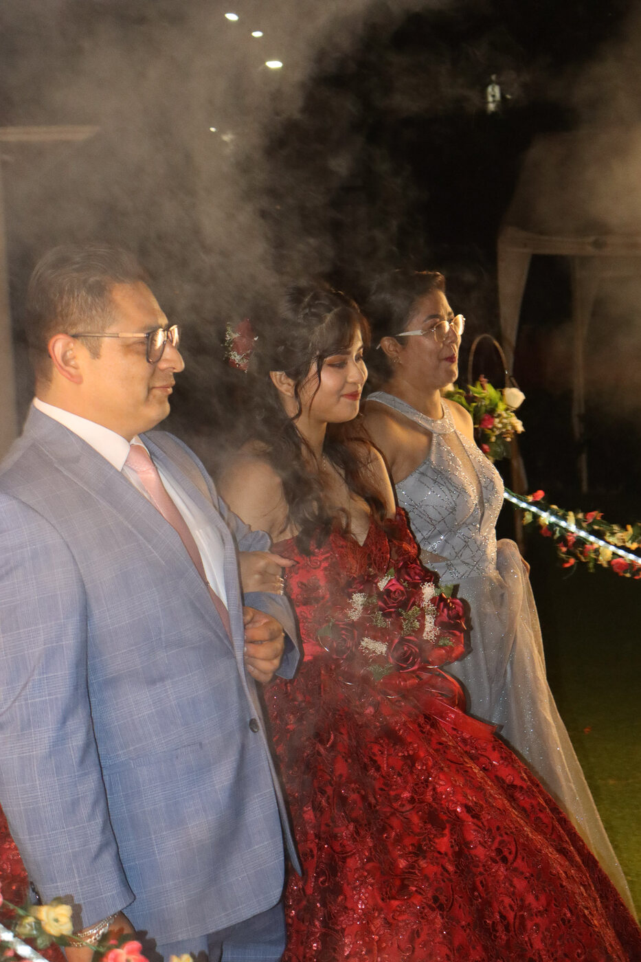 Presentación de la quinceañera entre humo junto a sus padres